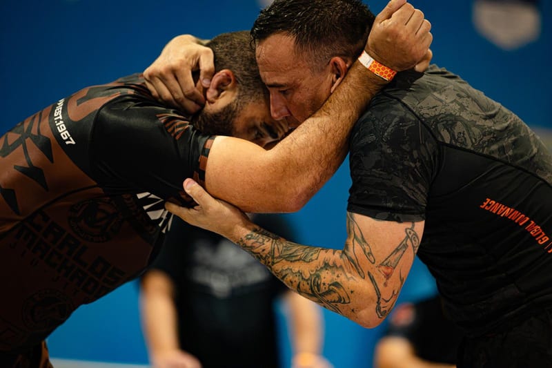 Two no-gi competitors lock up in a collar tie during an adult match.