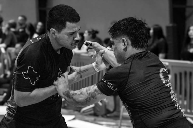 Black-and-white photo of two no-gi competitors fighting for wrist control.