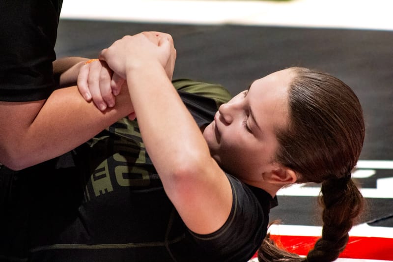 A girl works for arm control during a close no-gi exchange.