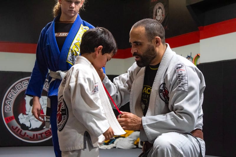 A boy in a white gi at a belt ceremony