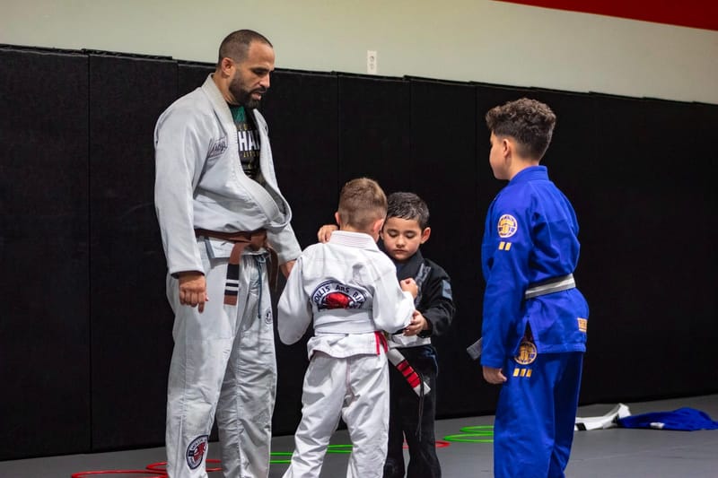 An instructor and three boys bowing at the start of class