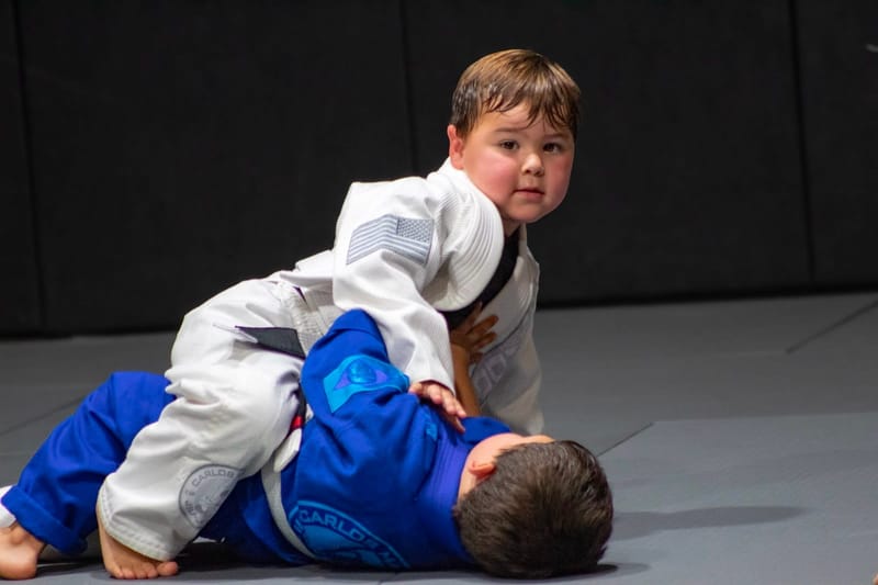 A child playing open guard over a partner