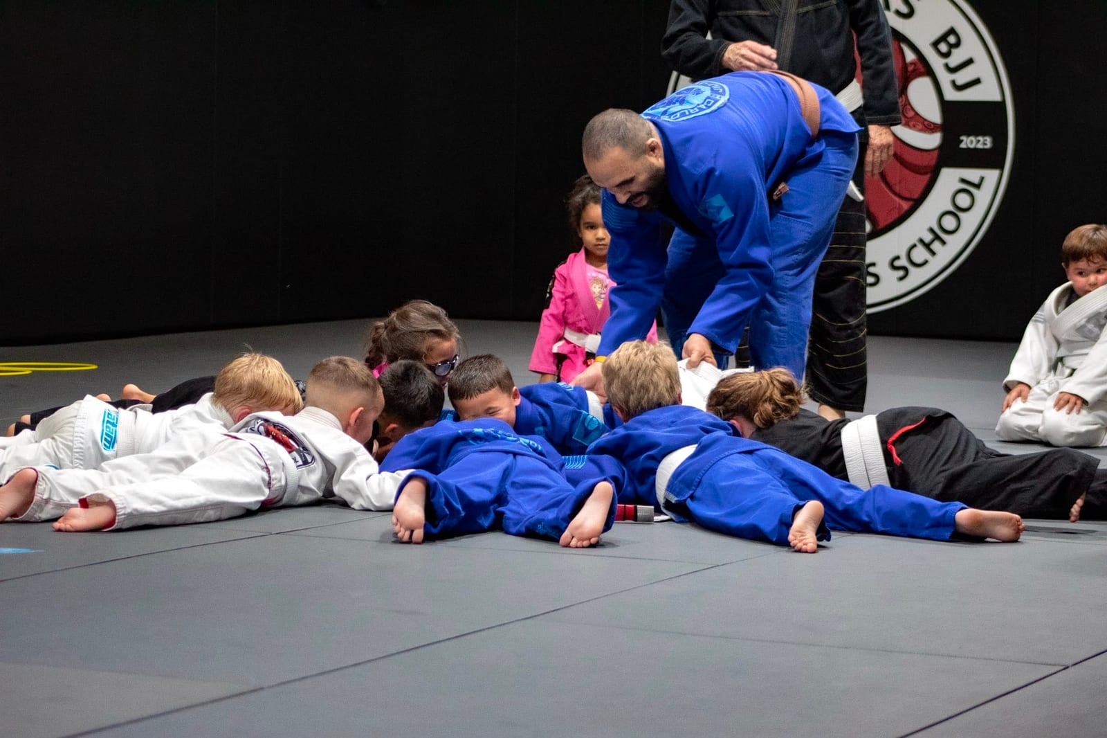 A Mollis Ars BJJ coach leading a row of young students at the start of class