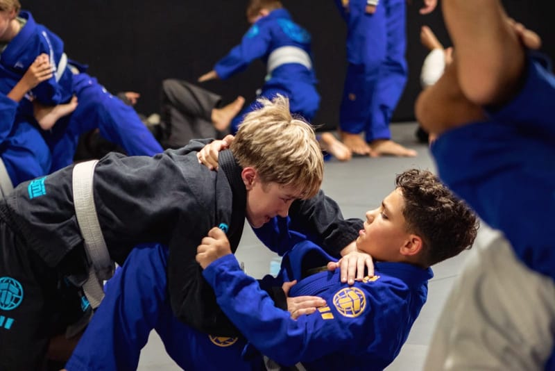 Two teens grip fighting in blue gis
