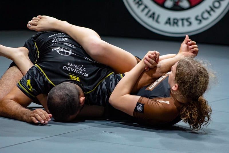 An athlete finishing an armbar from the bottom in competition